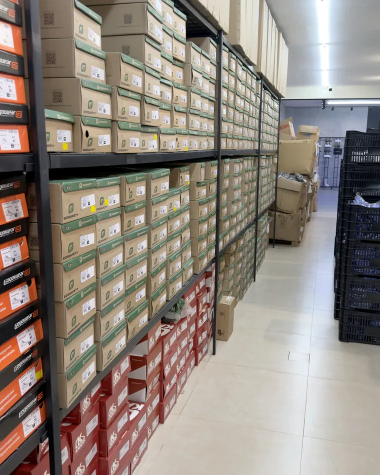 Estoque de calçados de segurança organizados em caixas